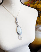 Artisan Bridewell stone pendant with white moonstone and CZ bead fringe shown on bust for scale