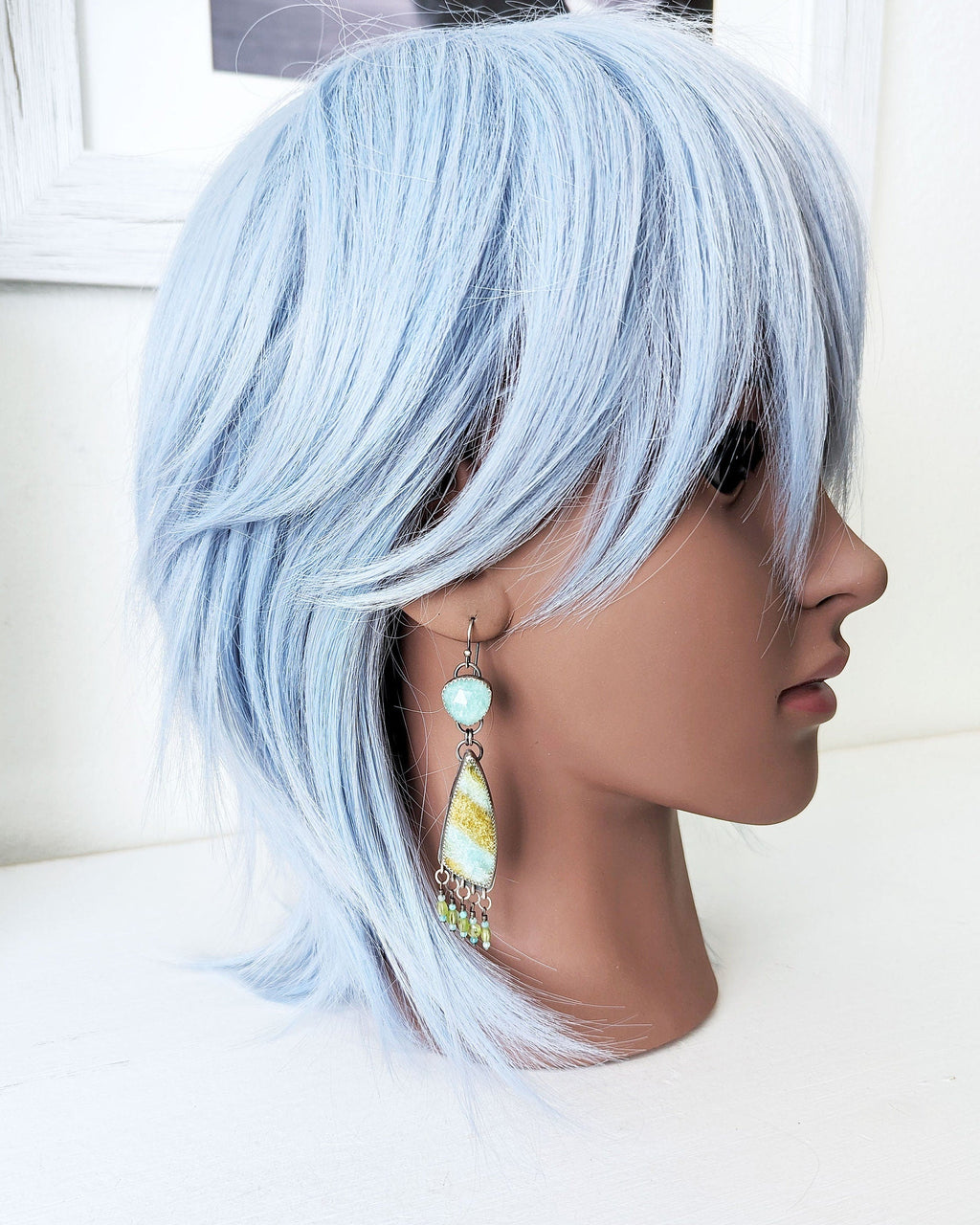 Nature inspired statement earrings with coastal blue and green tones on mannequin for scale