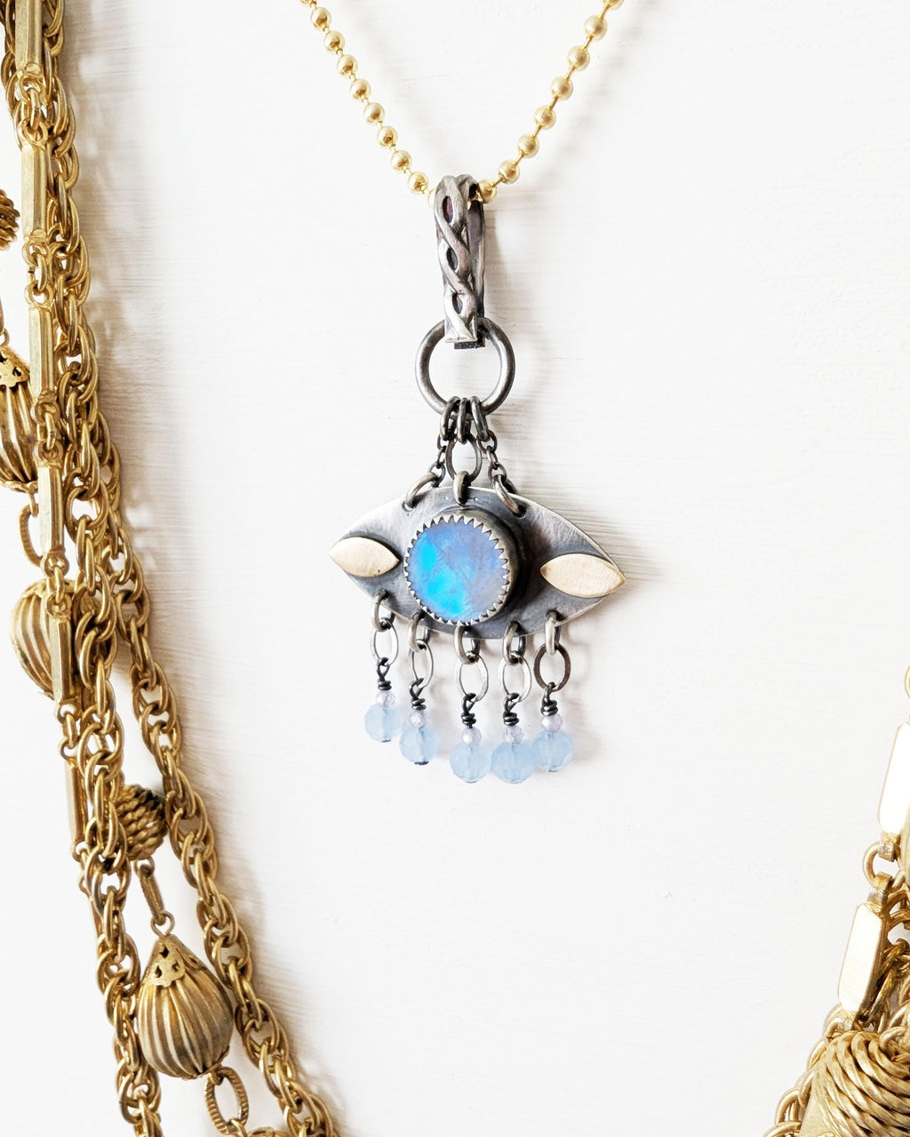 Small eye-shaped moonstone necklace with brass accents on chain with layer necklace (not included)