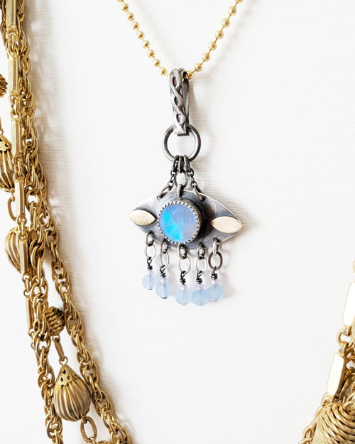 Small eye-shaped moonstone necklace with brass accents on chain with layer necklace (not included)