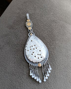 mixed metal pendant with carved mother of pearl and fringe