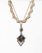 Artisan ammonite and simbircite pendant with pyrite fringe shown hanging with layering necklace for styling