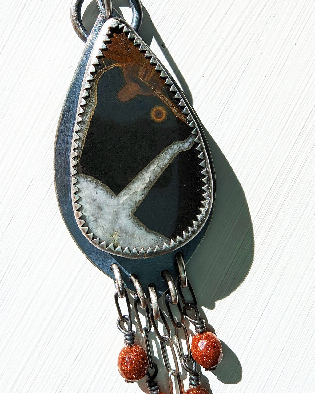 Boho artisan fossil earrings with chain fringe design close up of stone
