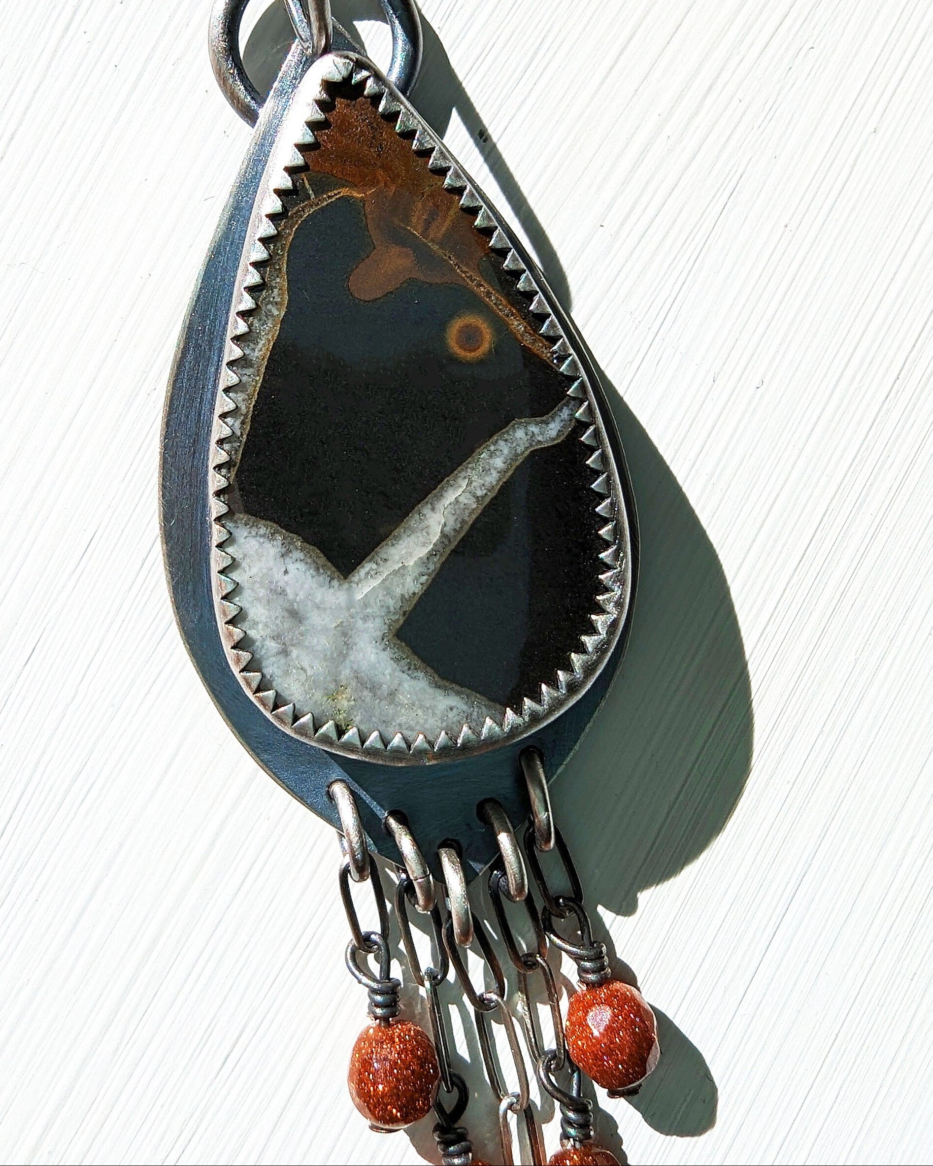 Boho artisan fossil earrings with chain fringe design close up of stone