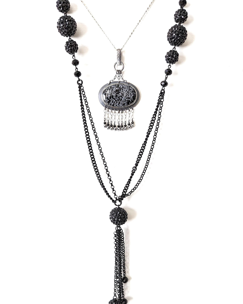 Snowflake obsidian pendant worn on chain layered with a bead necklace to show chandelier style width and length
