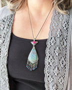 Artisan gemstone pendant with ruby in kyanite, pink jade, and blue topaz on bust for scale