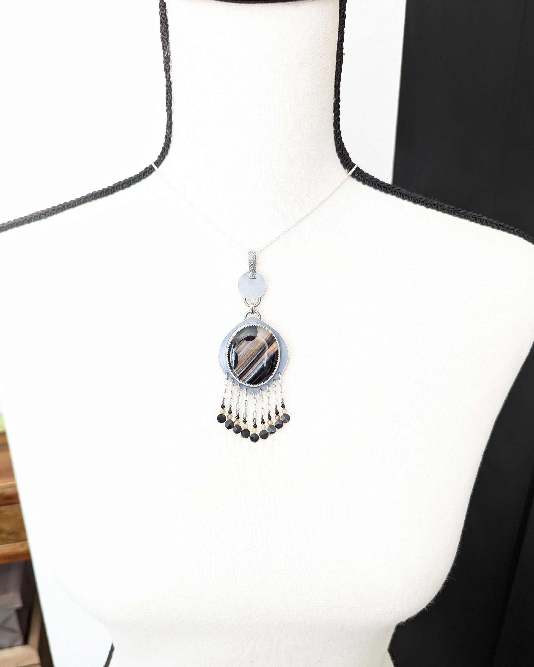 Statement boho pendant featuring black, brown, and white banded agate shown on bust for size