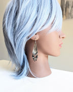 Hand-forged sterling silver arrow dangle earrings on mannequin for scale
