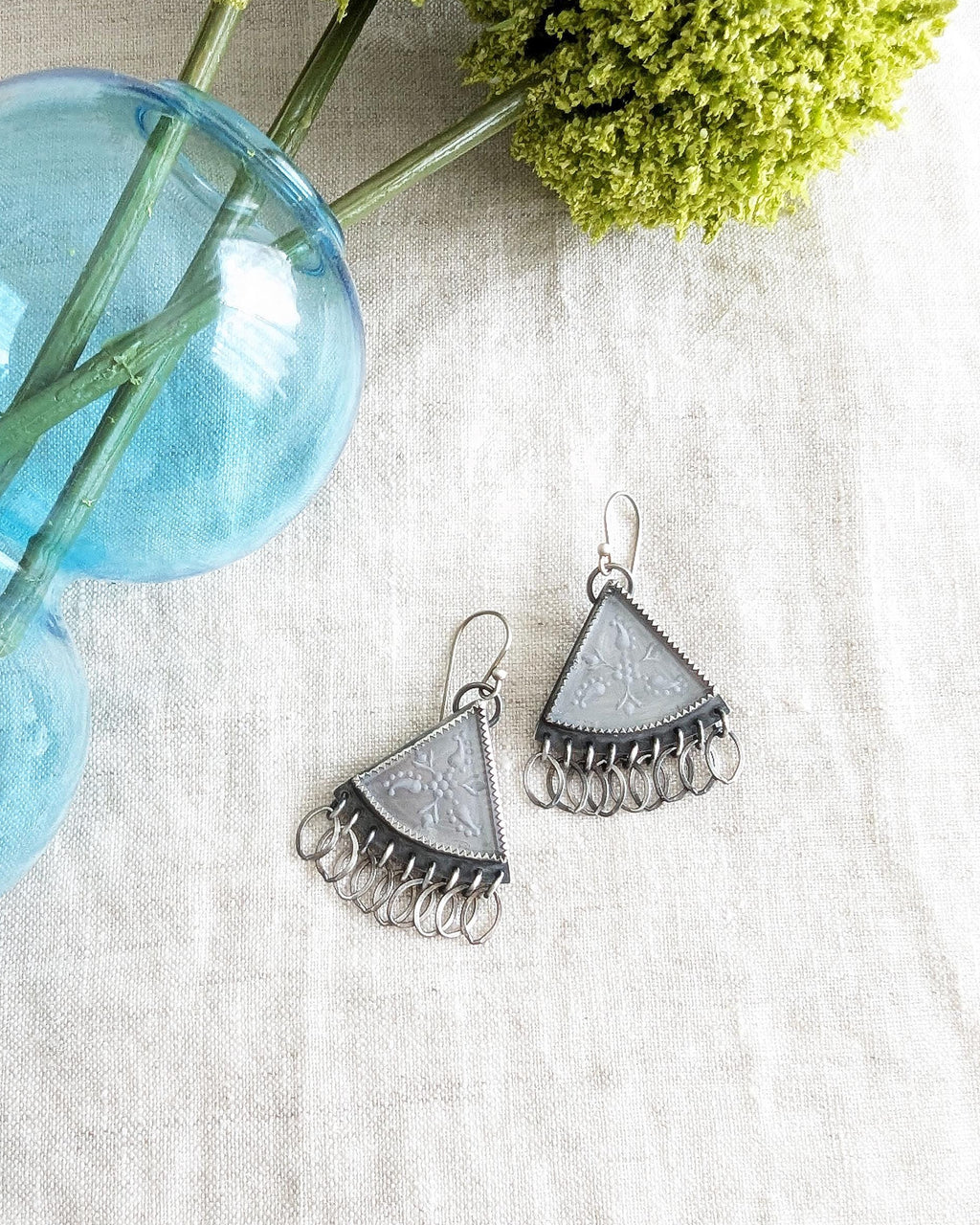 Etched quartz triangle earrings in oxidized sterling silver with leaf-link fringe on linen
