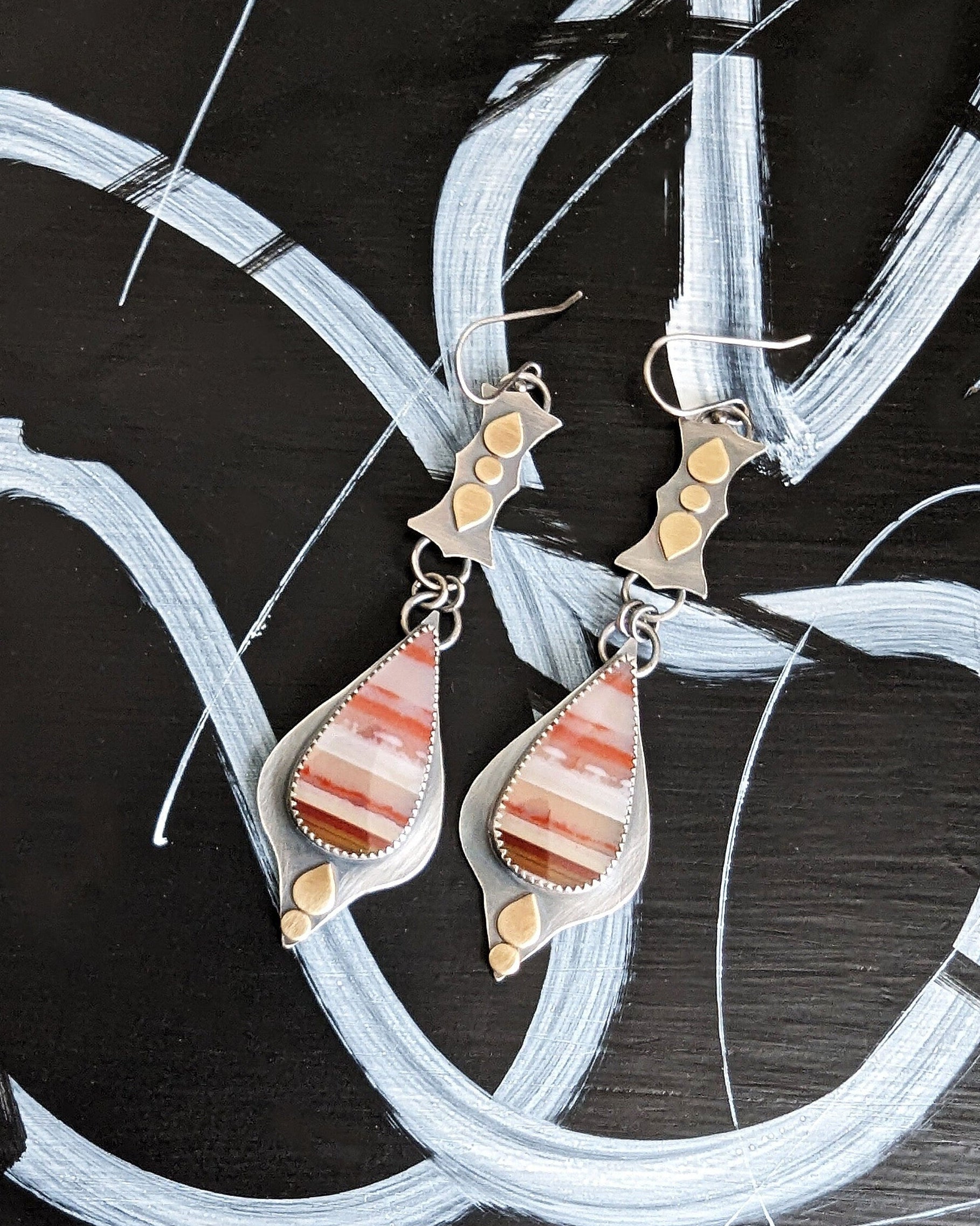 Opalized wood earrings with red and cream striped pattern