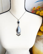 Mystical rainbow moonstone necklace with oxidized silver setting shown on bust for scale