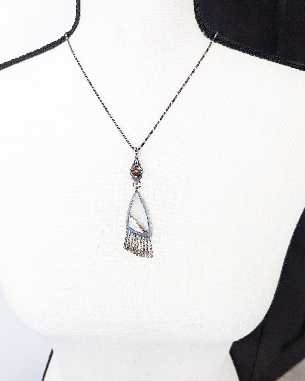 Artisan sterling silver pendant featuring lace agate swirl pattern shown on bust for scale