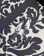 Sterling silver earrings with long chain fringe, green apatite, and black spinel beads on fabric
