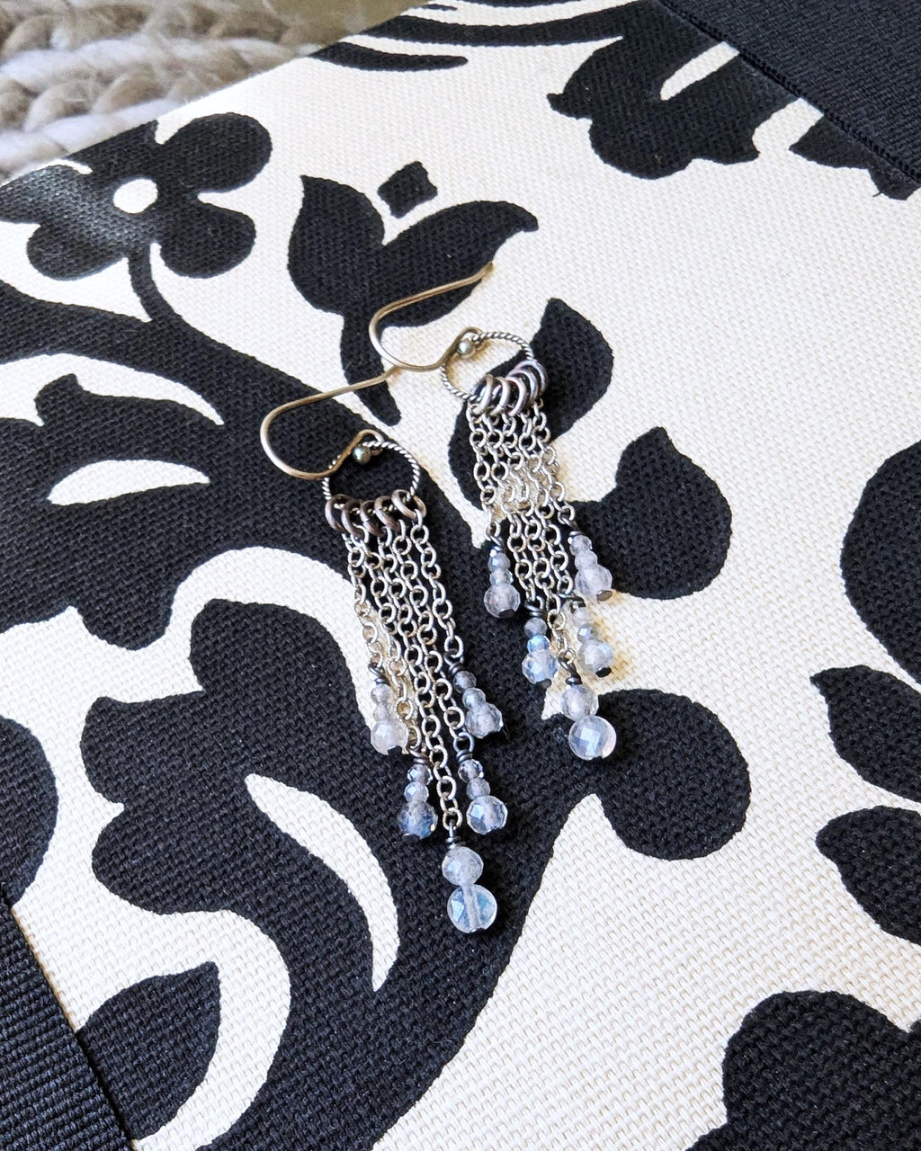 Minimalist long drop earrings featuring natural labradorite beads on fabric
