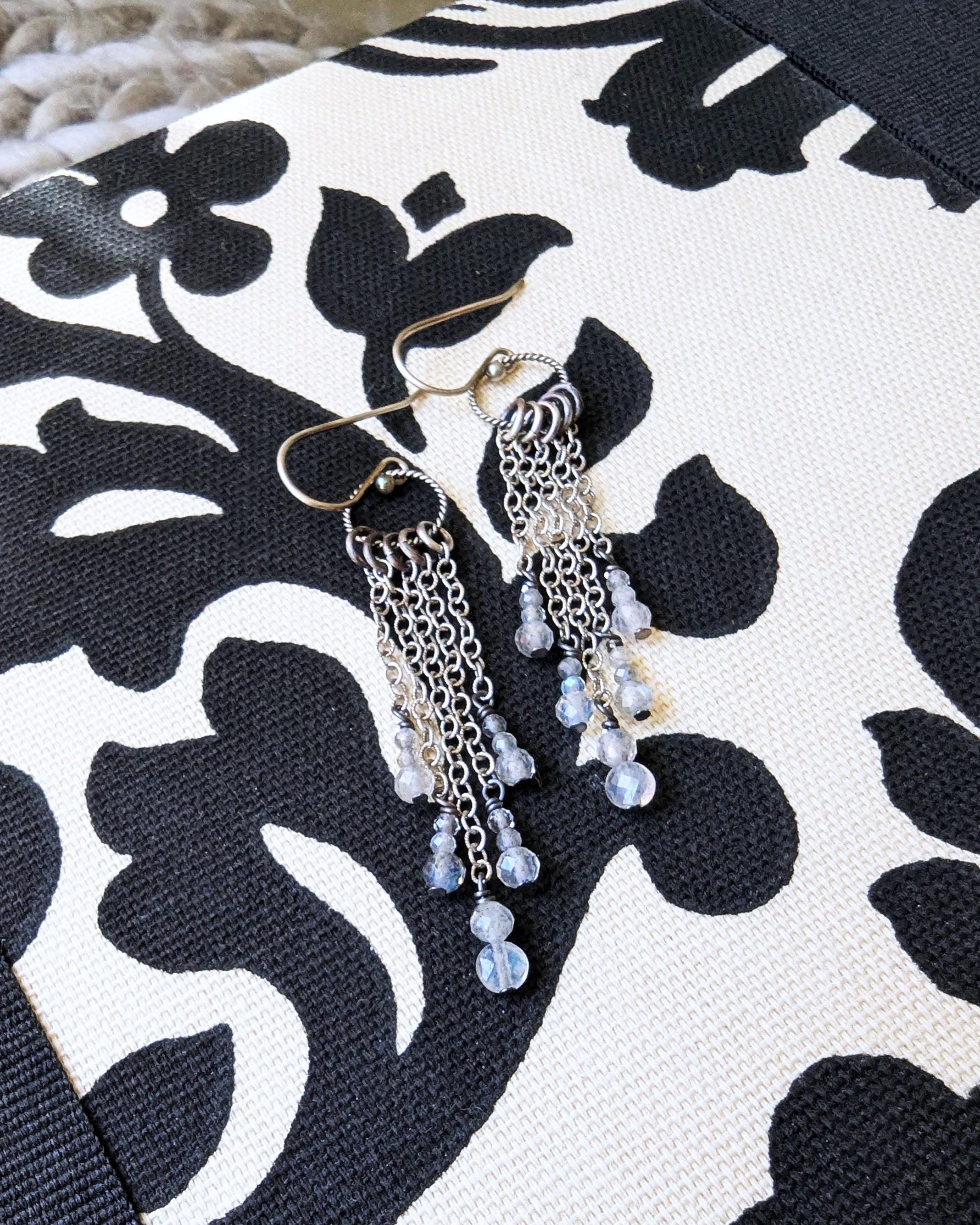 Minimalist long drop earrings featuring natural labradorite beads on fabric