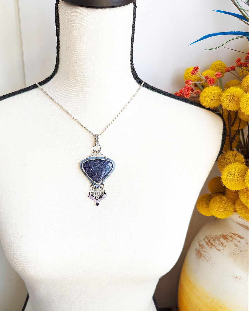 Sterling silver chandelier pendant with glittering copper-flecked goldstone shown on bust for scale