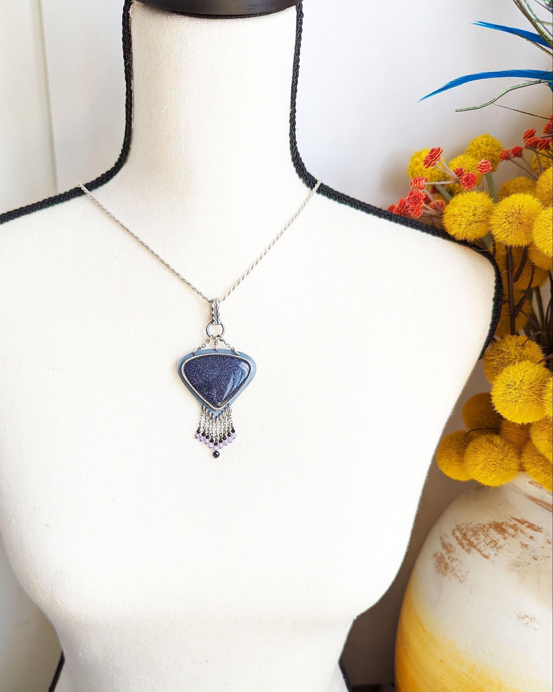 Sterling silver chandelier pendant with glittering copper-flecked goldstone shown on bust for scale