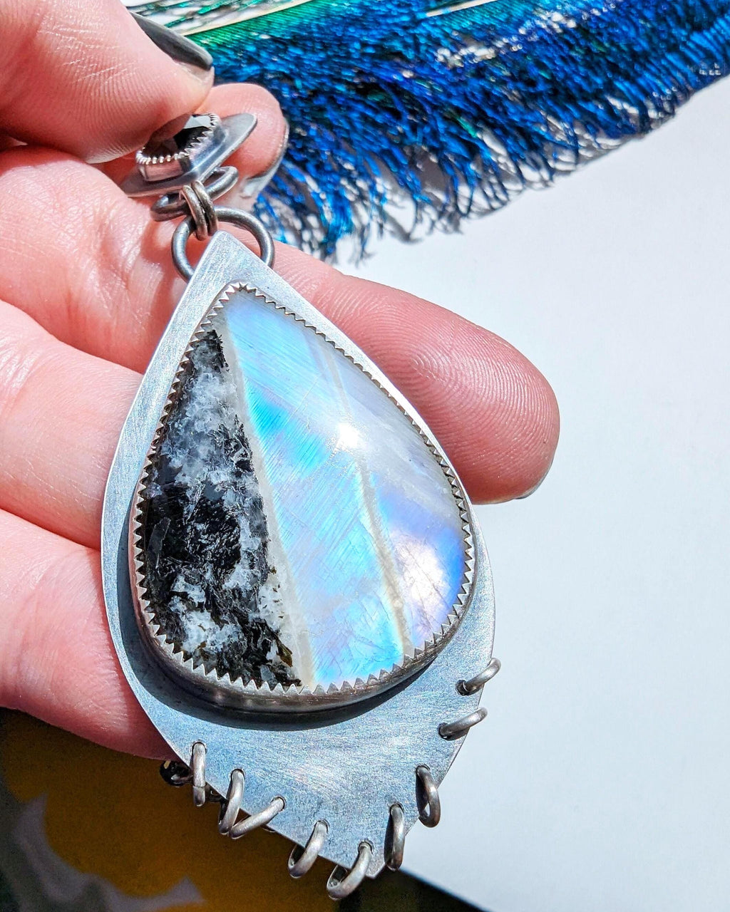 Close up of tourmaline-striped rainbow moonstone with colorful flash detail