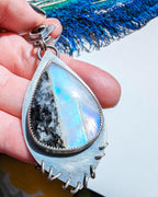 Close up of tourmaline-striped rainbow moonstone with colorful flash detail