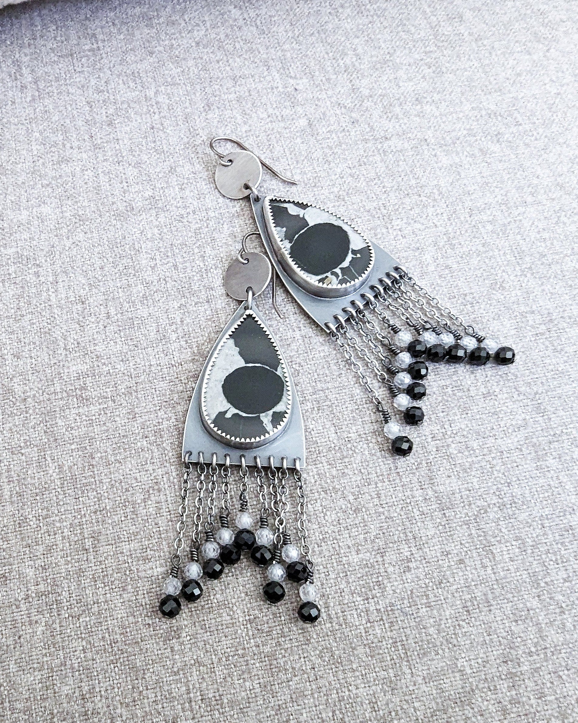 Close-up of pear-shaped septarian fossil earrings showing natural patterns
on fabric