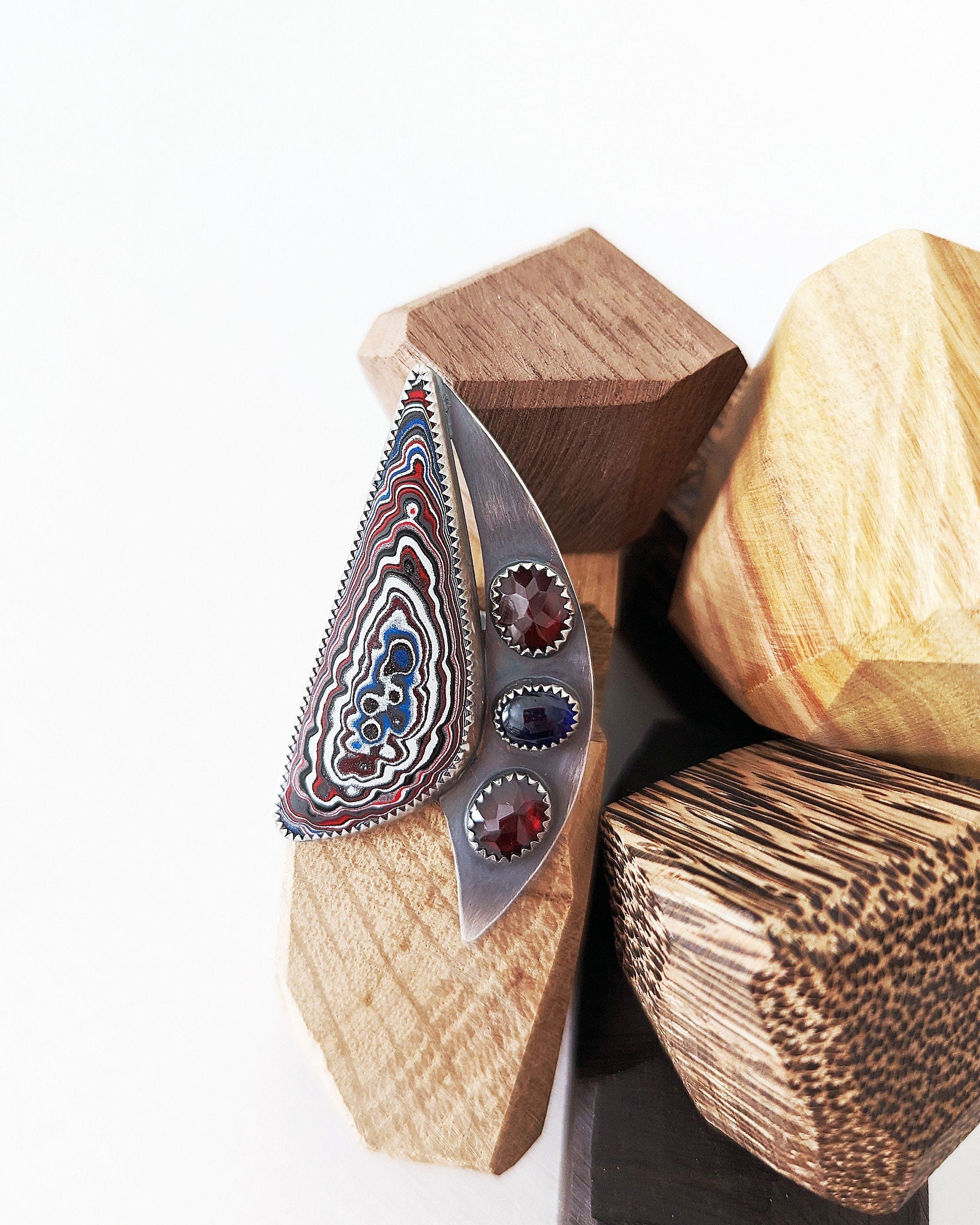 Abstract sailboat Fordite ring with red garnet and blue sapphire accents