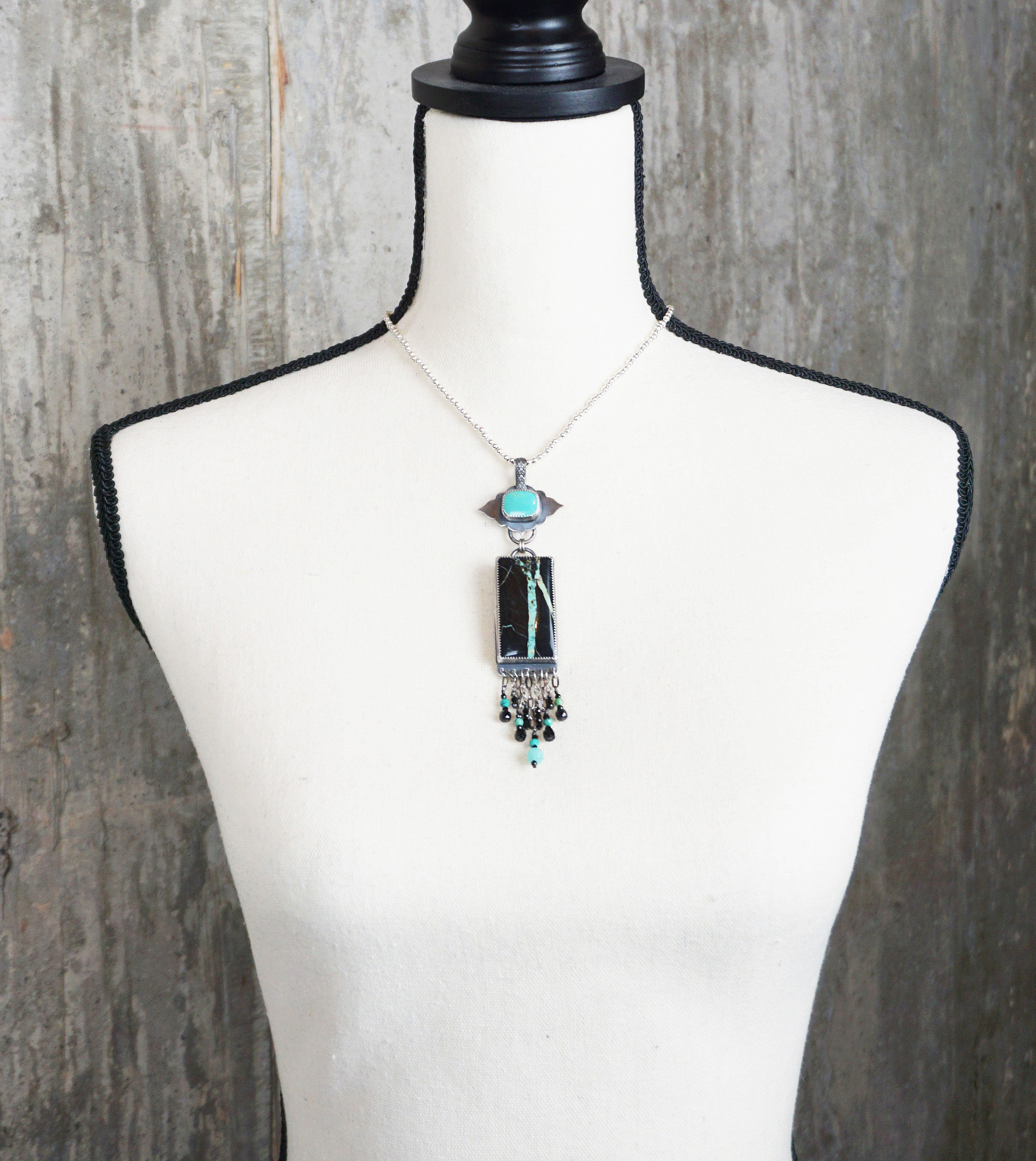 bold turquoise necklace with amazonite and black spinel beads on bust for scale