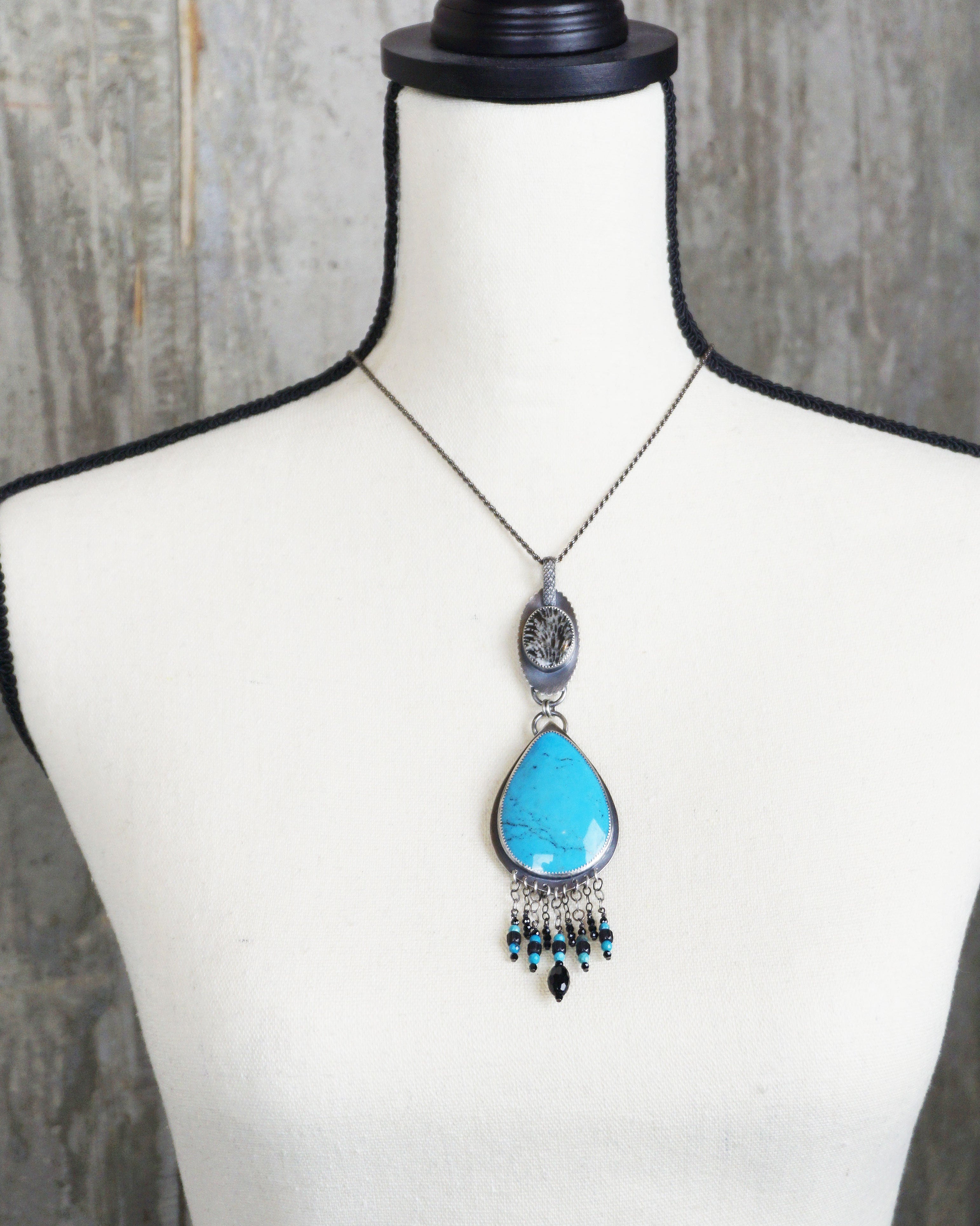 mexican turquoise jewelry with vivid blue stone and black accents on bust for scale