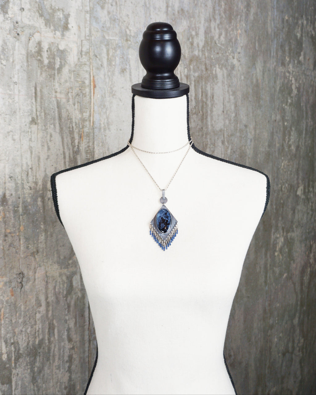 unique blue stone necklace with fluid movement design on bust for scale (chain not included)