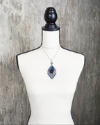 unique blue stone necklace with fluid movement design on bust for scale (chain not included)