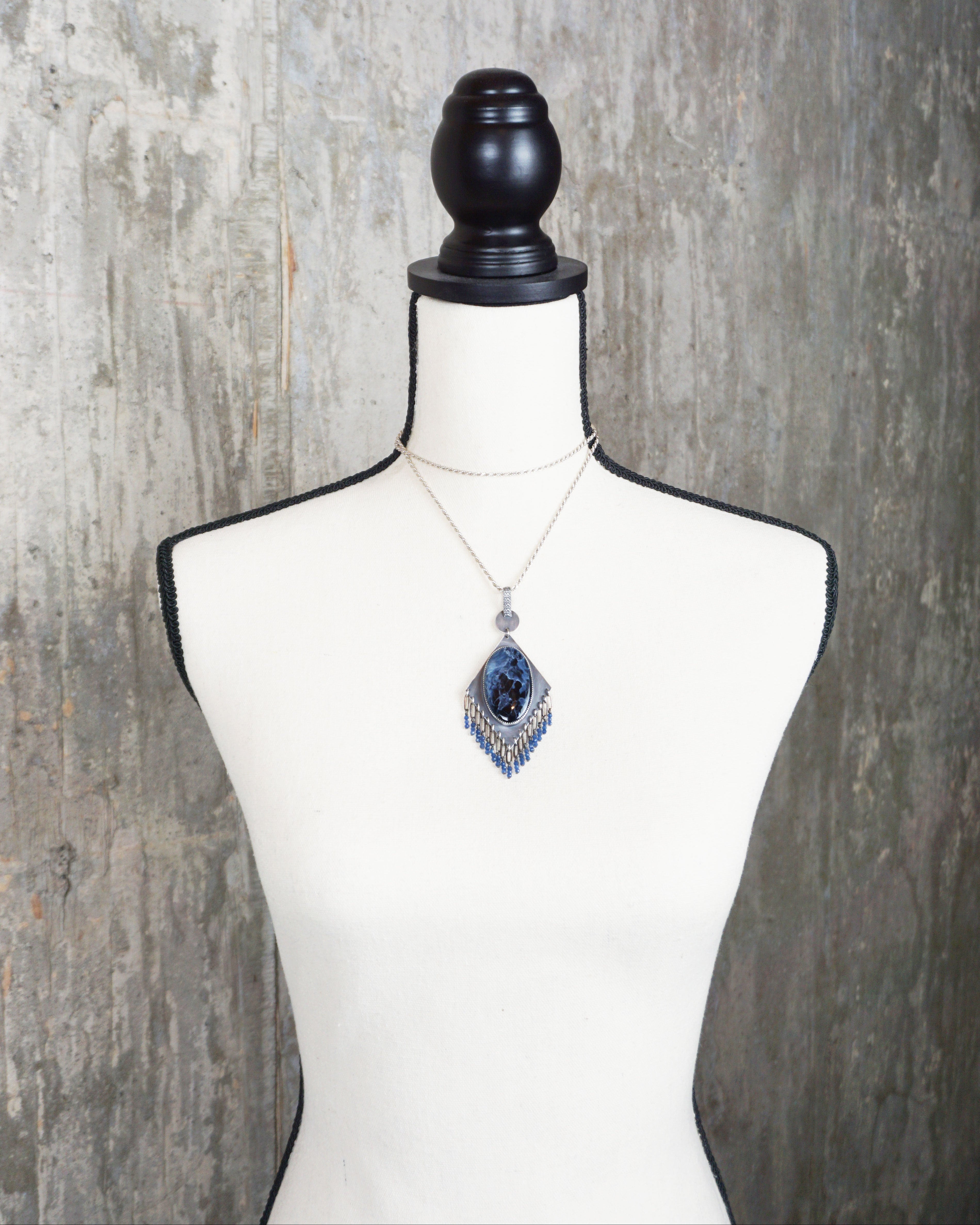 unique blue stone necklace with fluid movement design on bust for scale (chain not included)