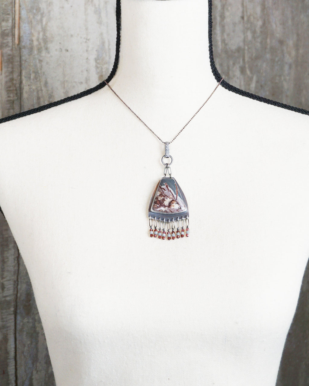 bold oxidized silver pendant with natural patterned stone on bust for scale (chain not included)