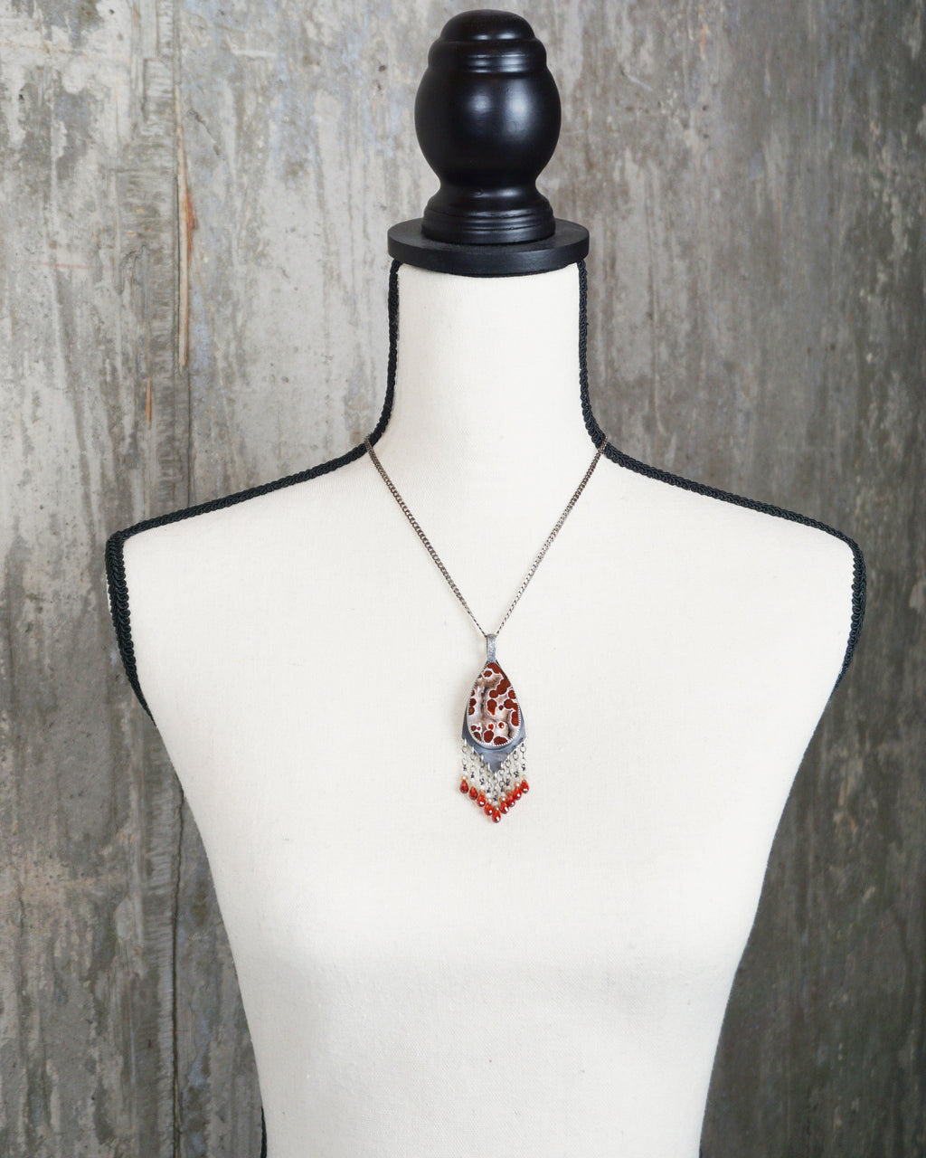 handcrafted silver pendant with vibrant gemstone fringe on bust for scale (chain not included)