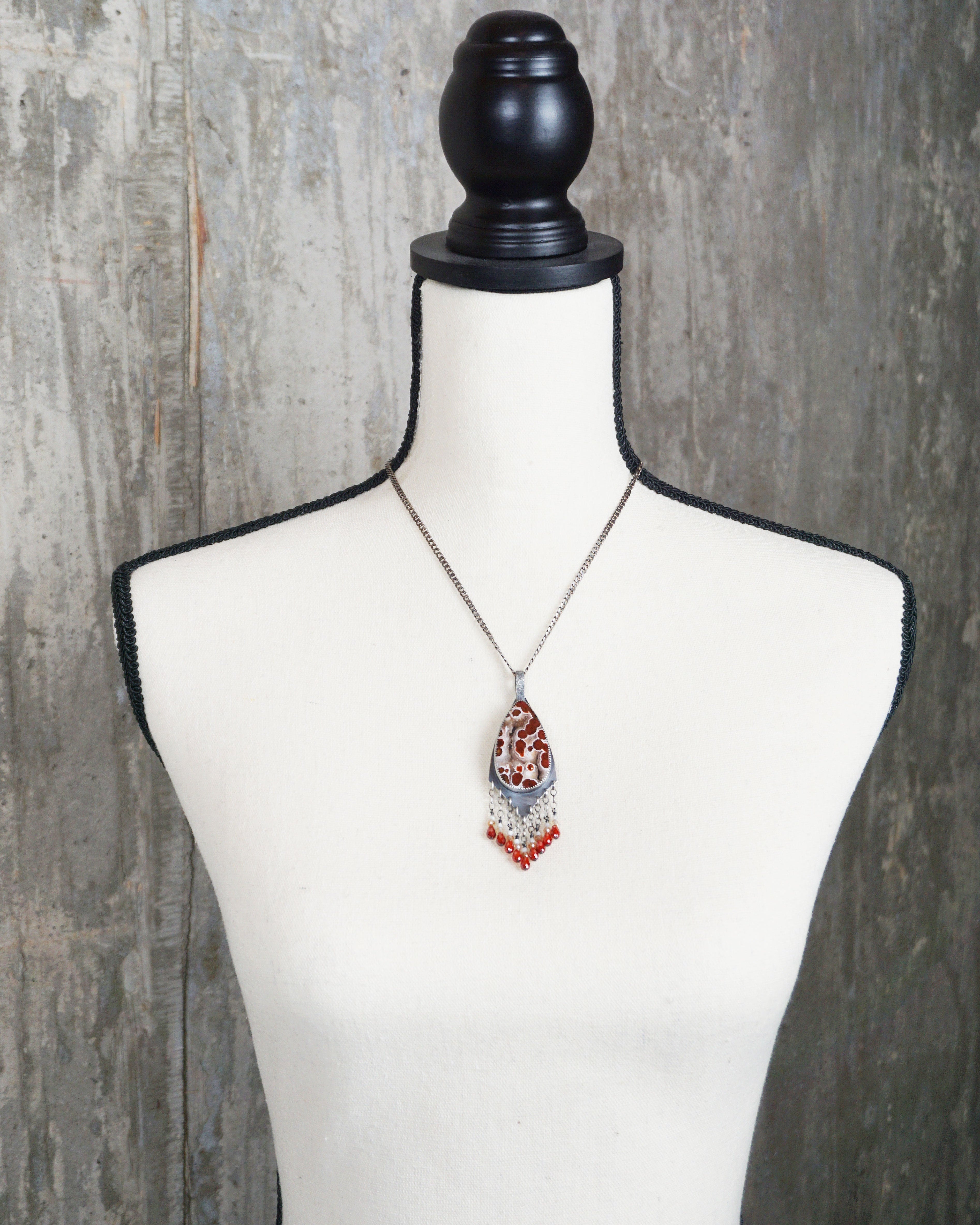 handcrafted silver pendant with vibrant gemstone fringe on bust for scale (chain not included)
