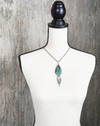 nature inspired pendant with turquoise magnesite and crystal accents on bust for scale (chain not included)