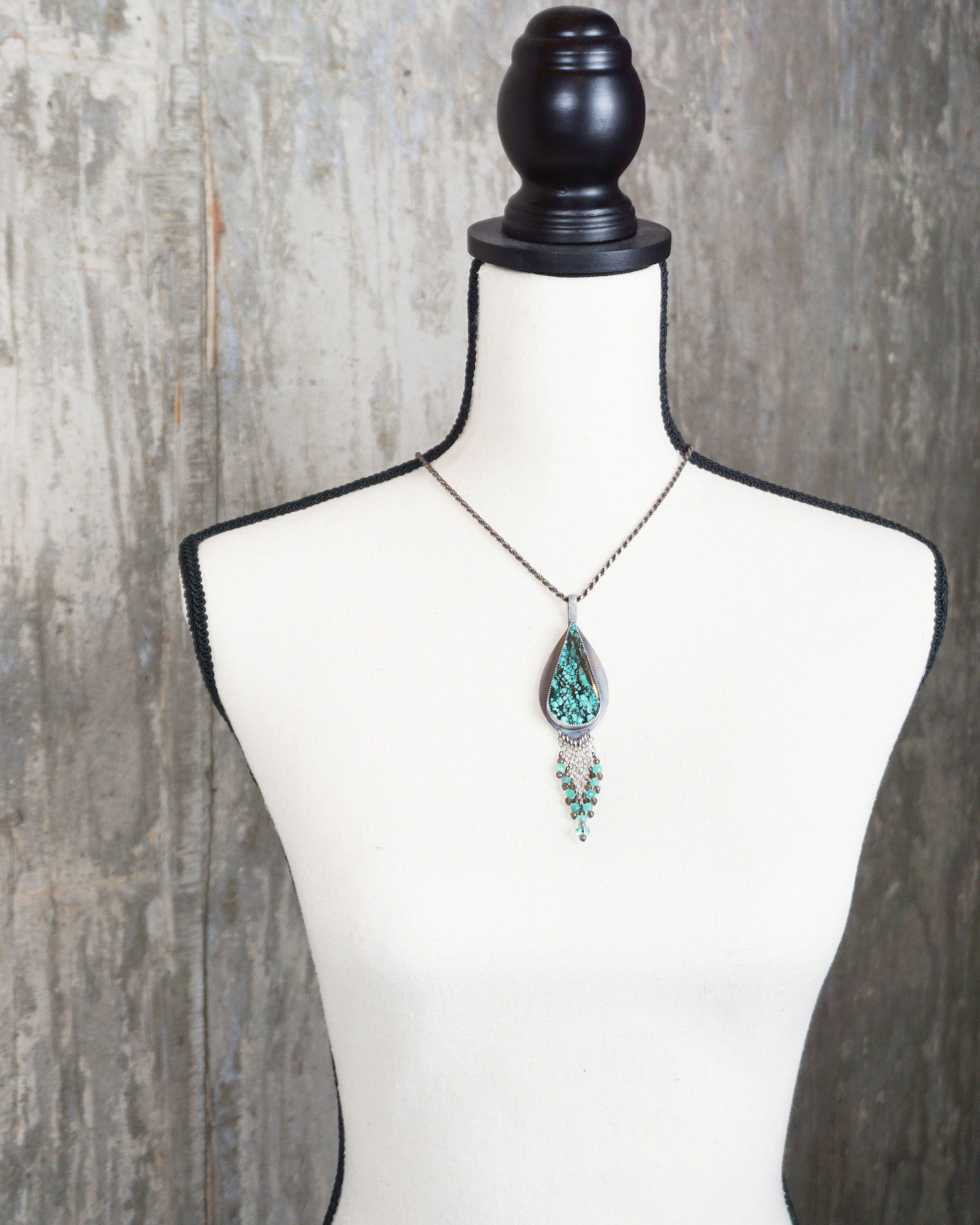 nature inspired pendant with turquoise magnesite and crystal accents on bust for scale (chain not included)