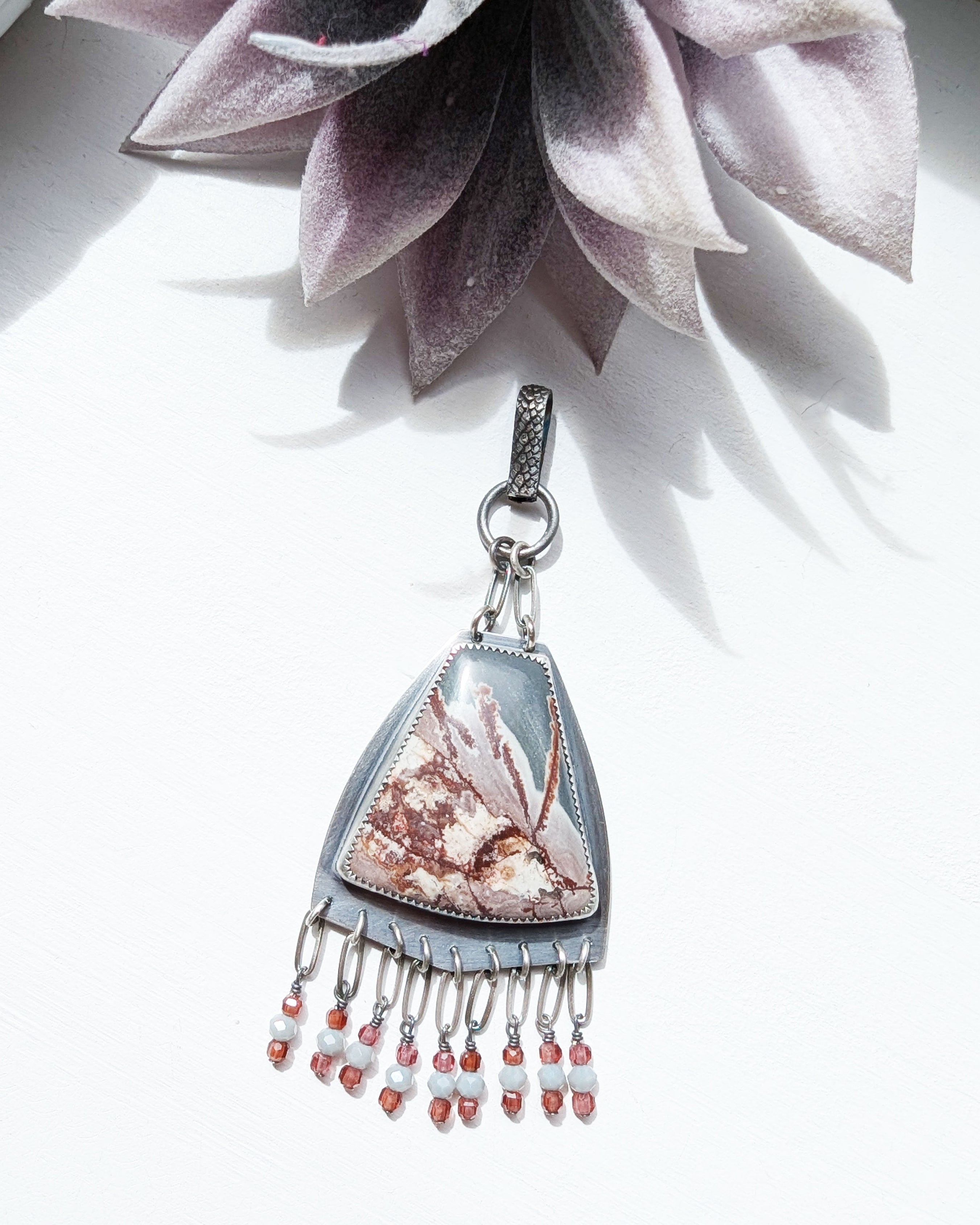 large shield pendant with multicolor rhyolite stone