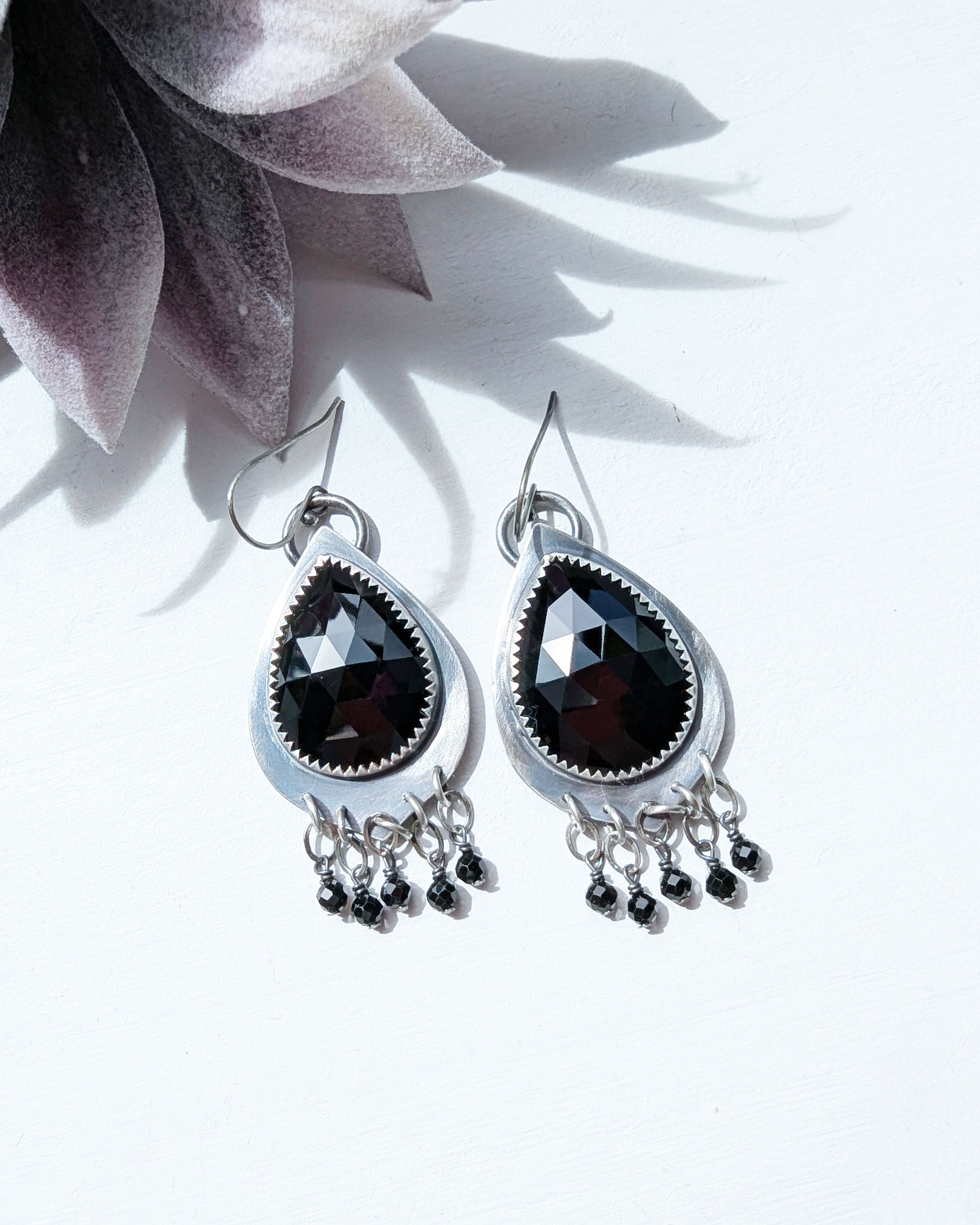 dark statement earrings with pear shaped silver and black gemstones