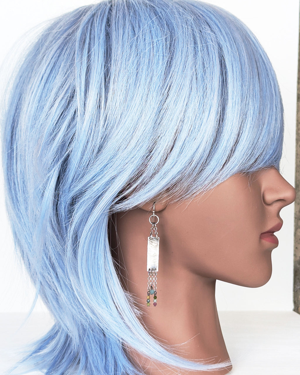 artisan silver drop earrings with asymmetrical beaded fringe on mannequin for scale