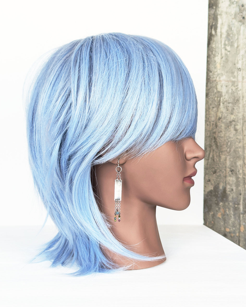 modern rustic silver earrings with long chain and gemstone detail on mannequin for scale