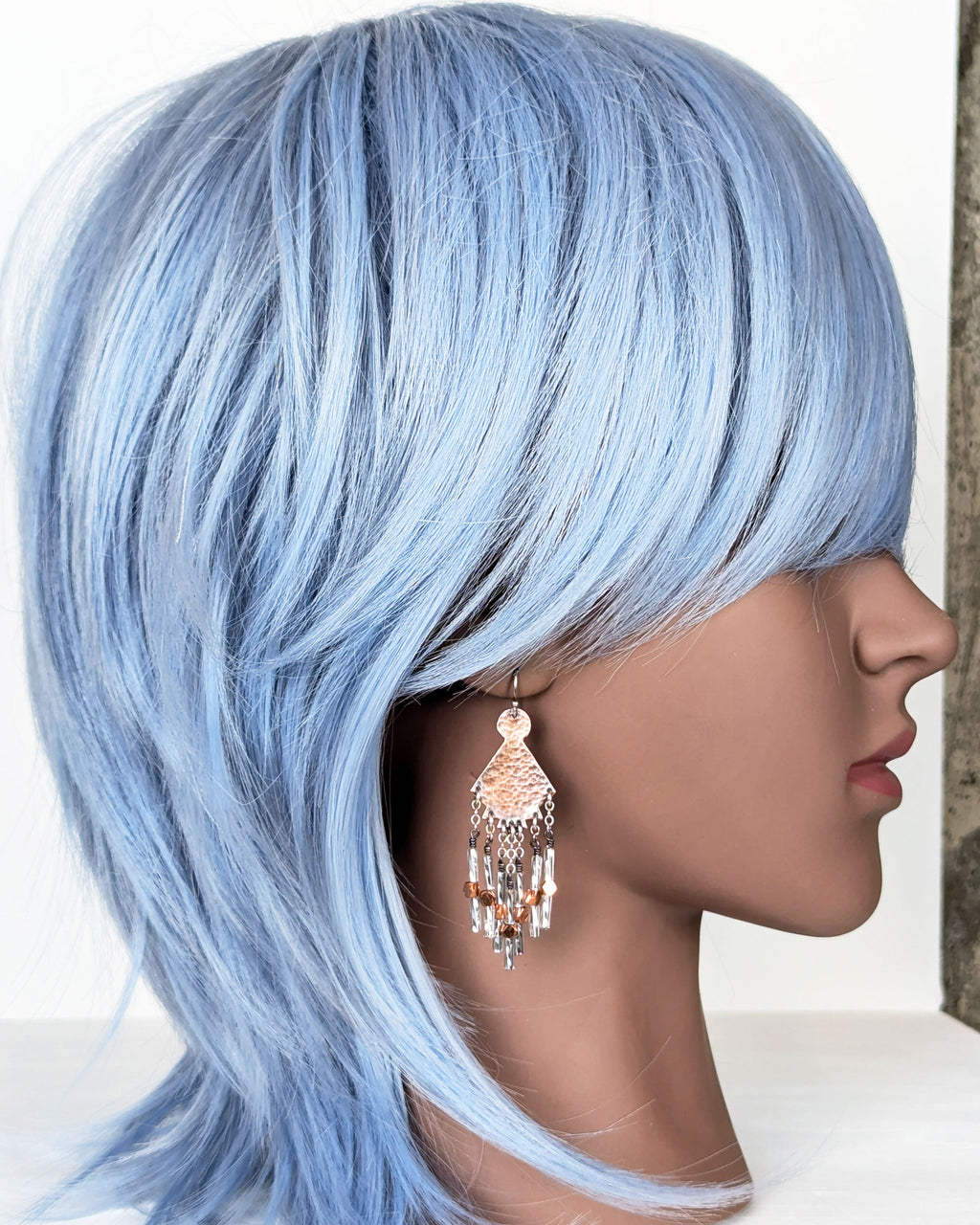 southwestern artisan earrings with copper and silver tones on mannequin for scale