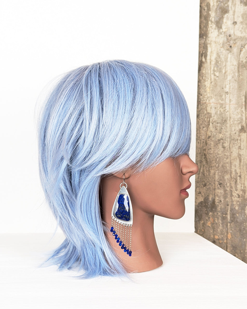 handcrafted oxidized silver earrings with large lapis stones on mannequin for scale