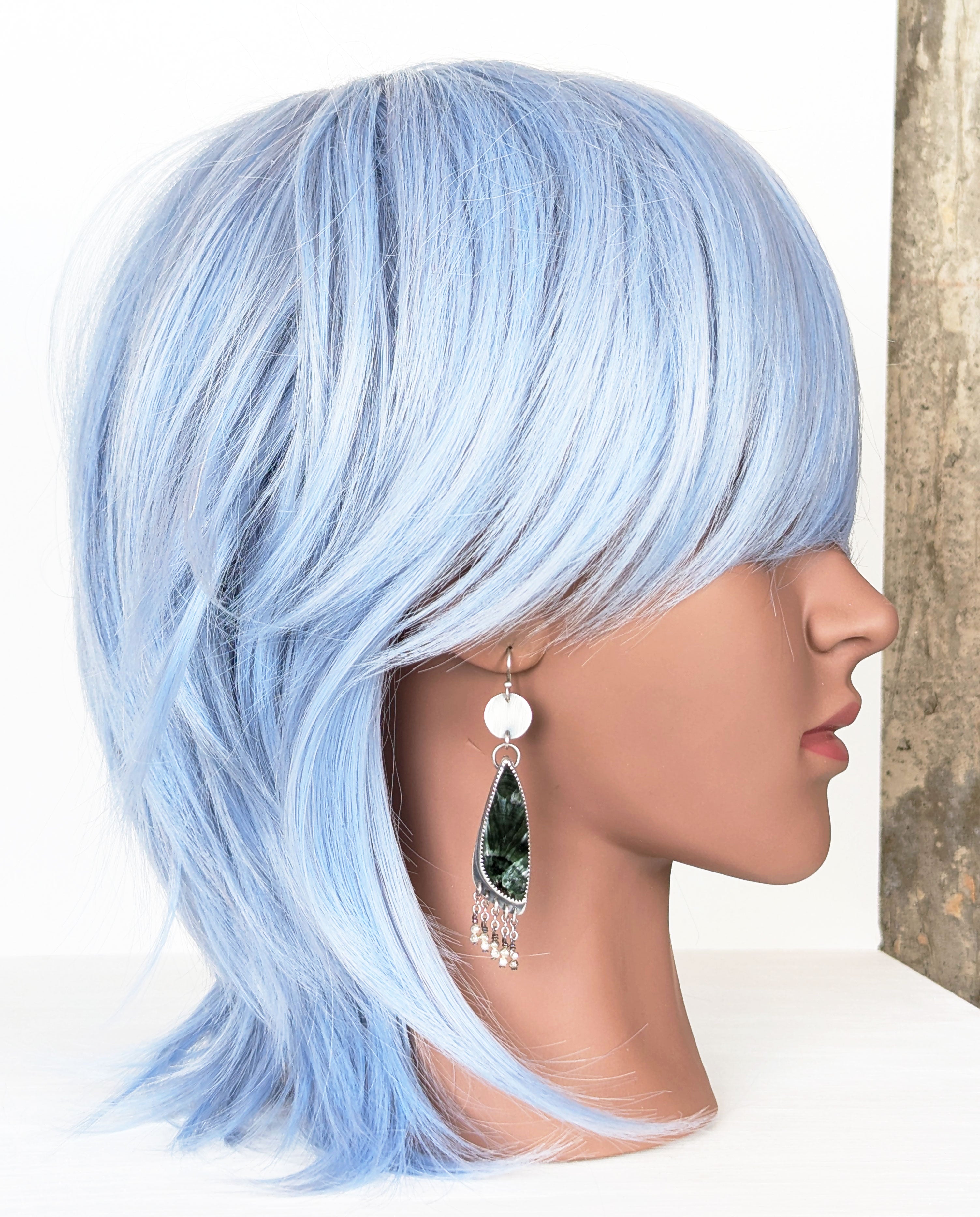 handcrafted oxidized silver earrings with pine green seraphinite on mannequin for scale