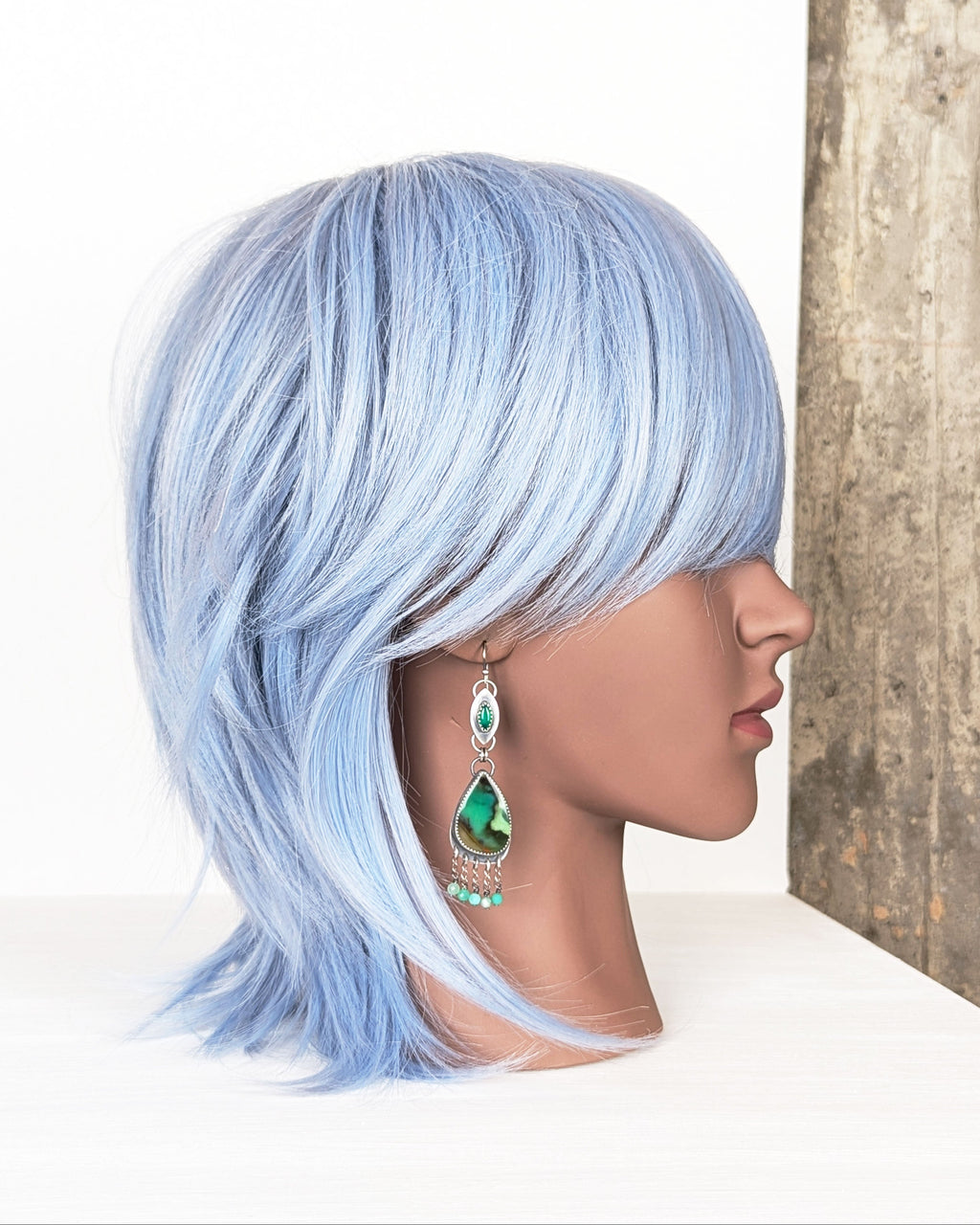 boho luxury earrings with vivid green tones and fringe on mannequin for scale