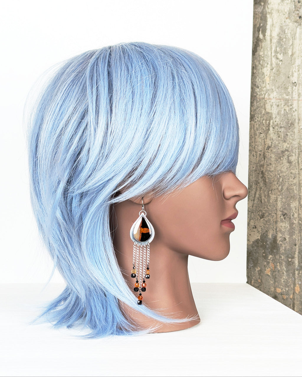 long fringe earrings with orange and black agate stones on mannequin for scale