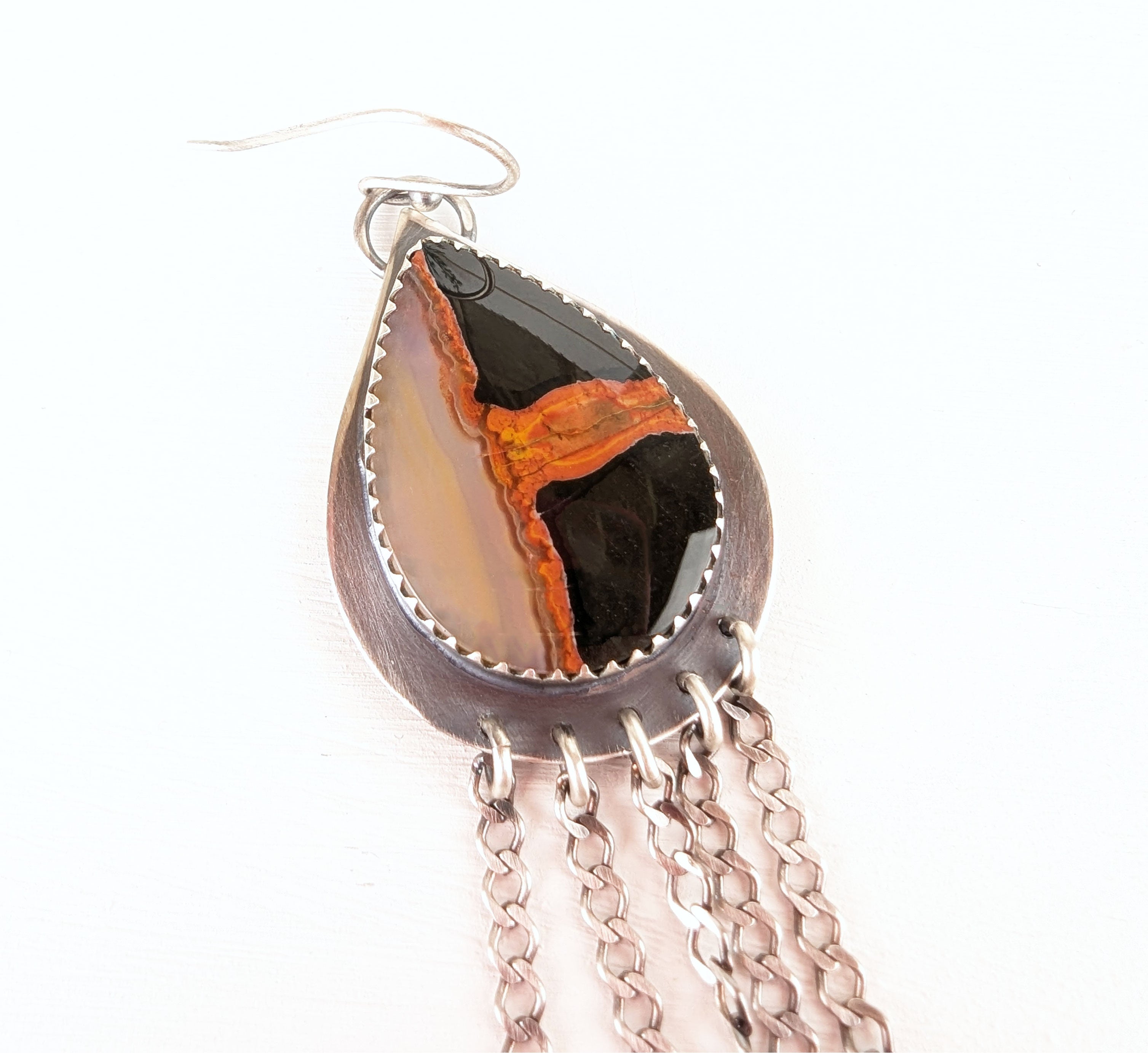 Close up of autumn inspired earrings with warm orange and dark toned agate stones