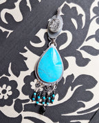 one of a kind turquoise pendant with sculptural coral bail