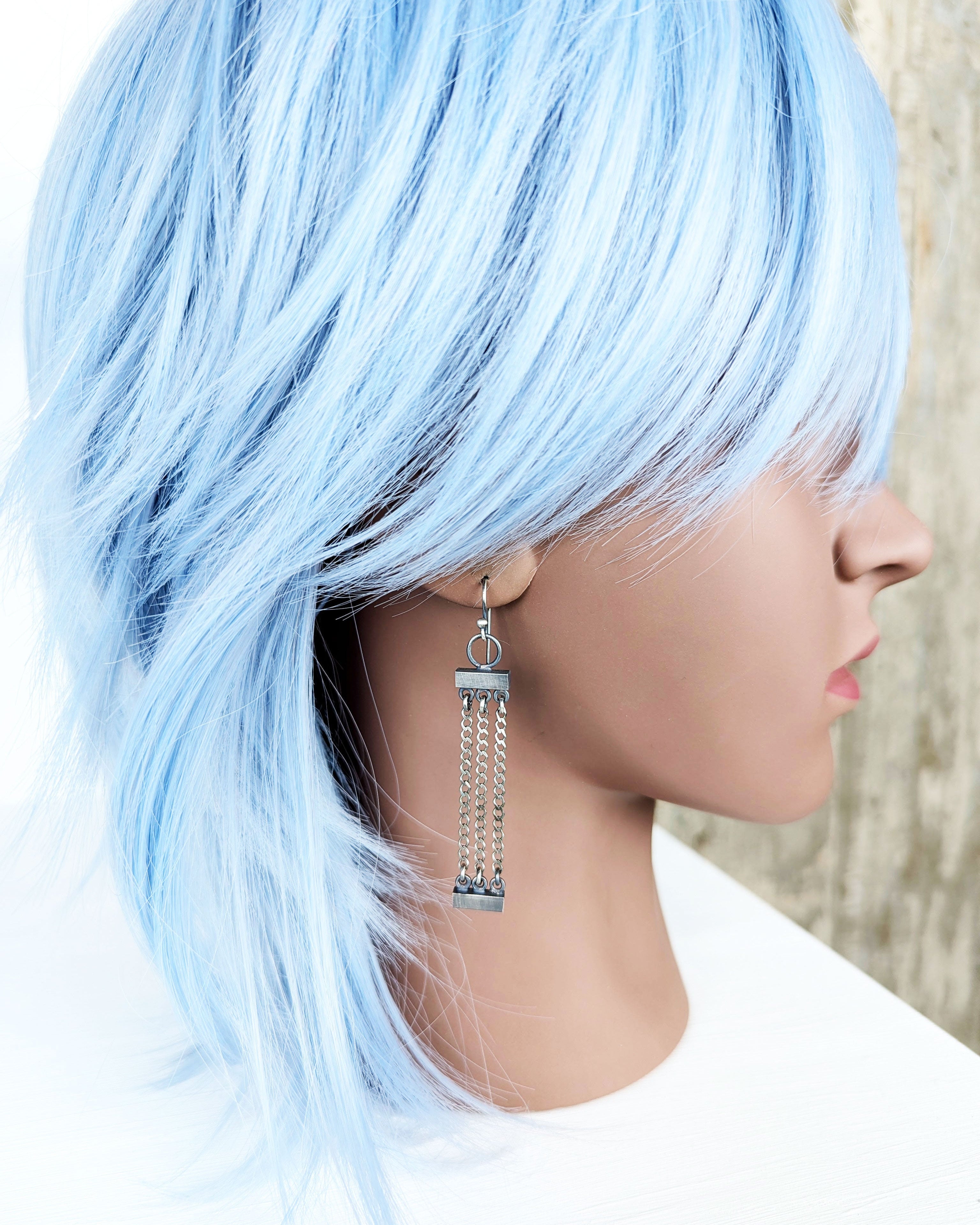 handcrafted industrial sterling silver earrings with triple chain design on bust for scale