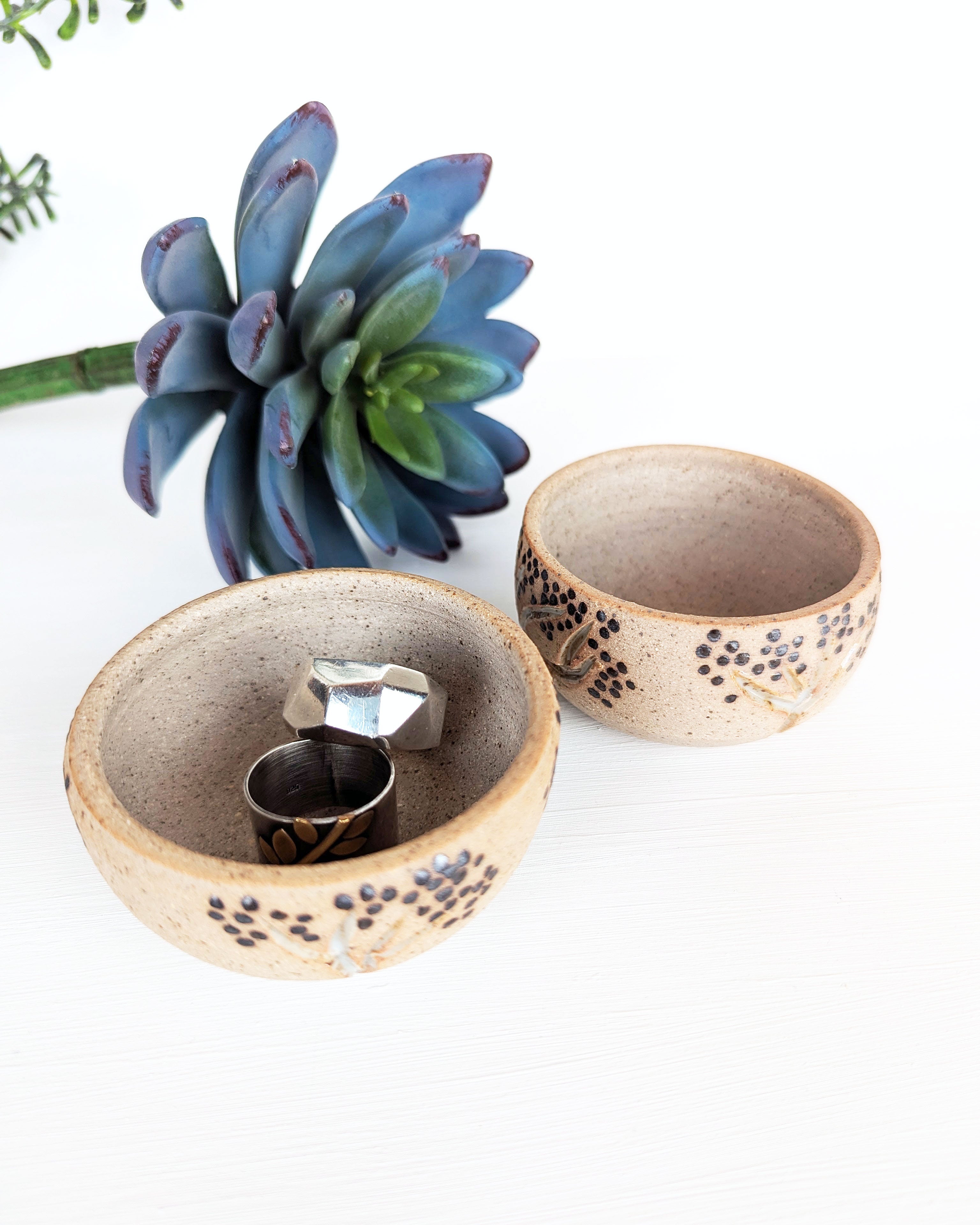 Hand-thrown stoneware jewelry bowls featuring black dotted aspen tree designs on warm natural clay.