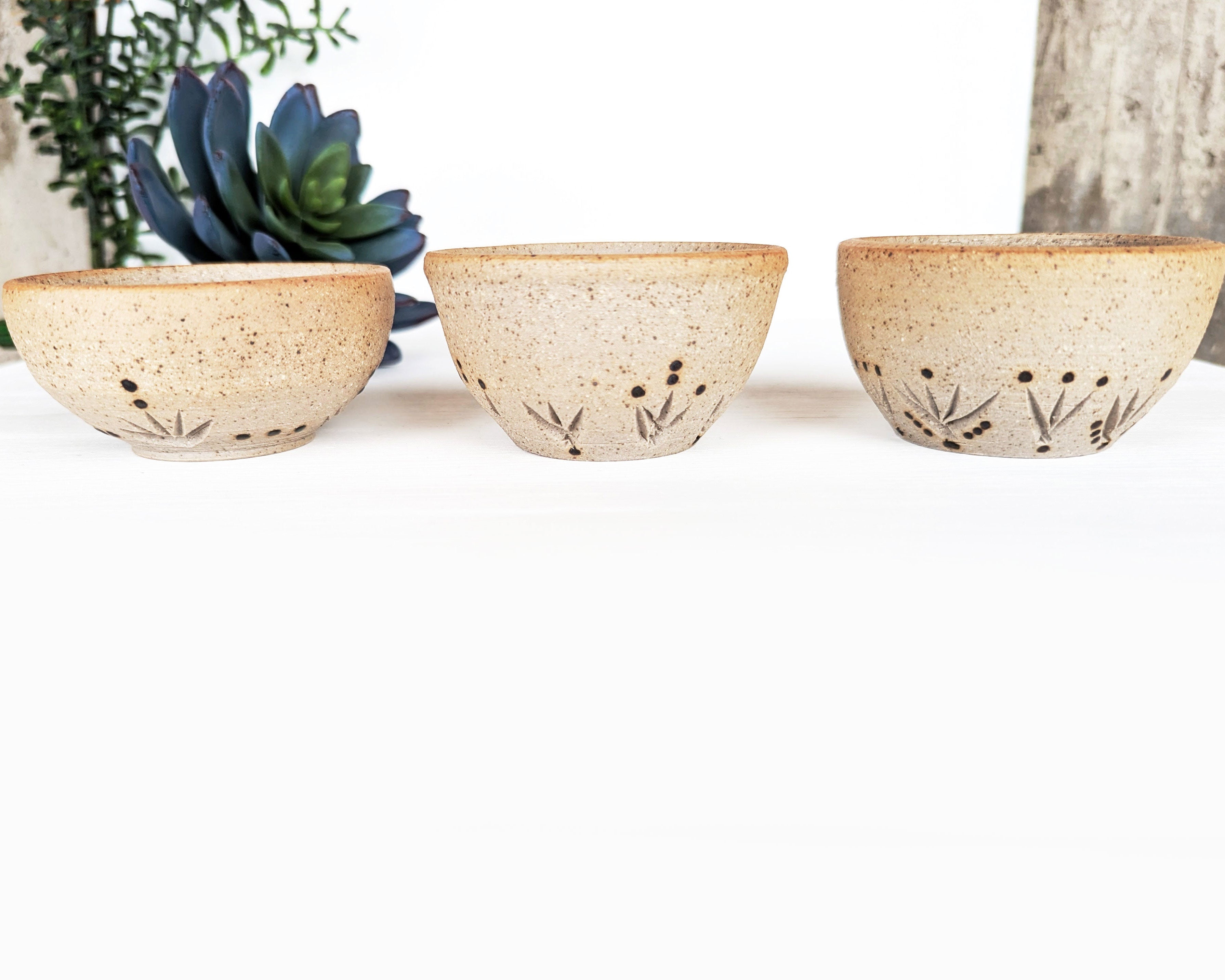 Hand-thrown stoneware pottery bowls featuring hand-carved patterns and rustic Southwestern style.