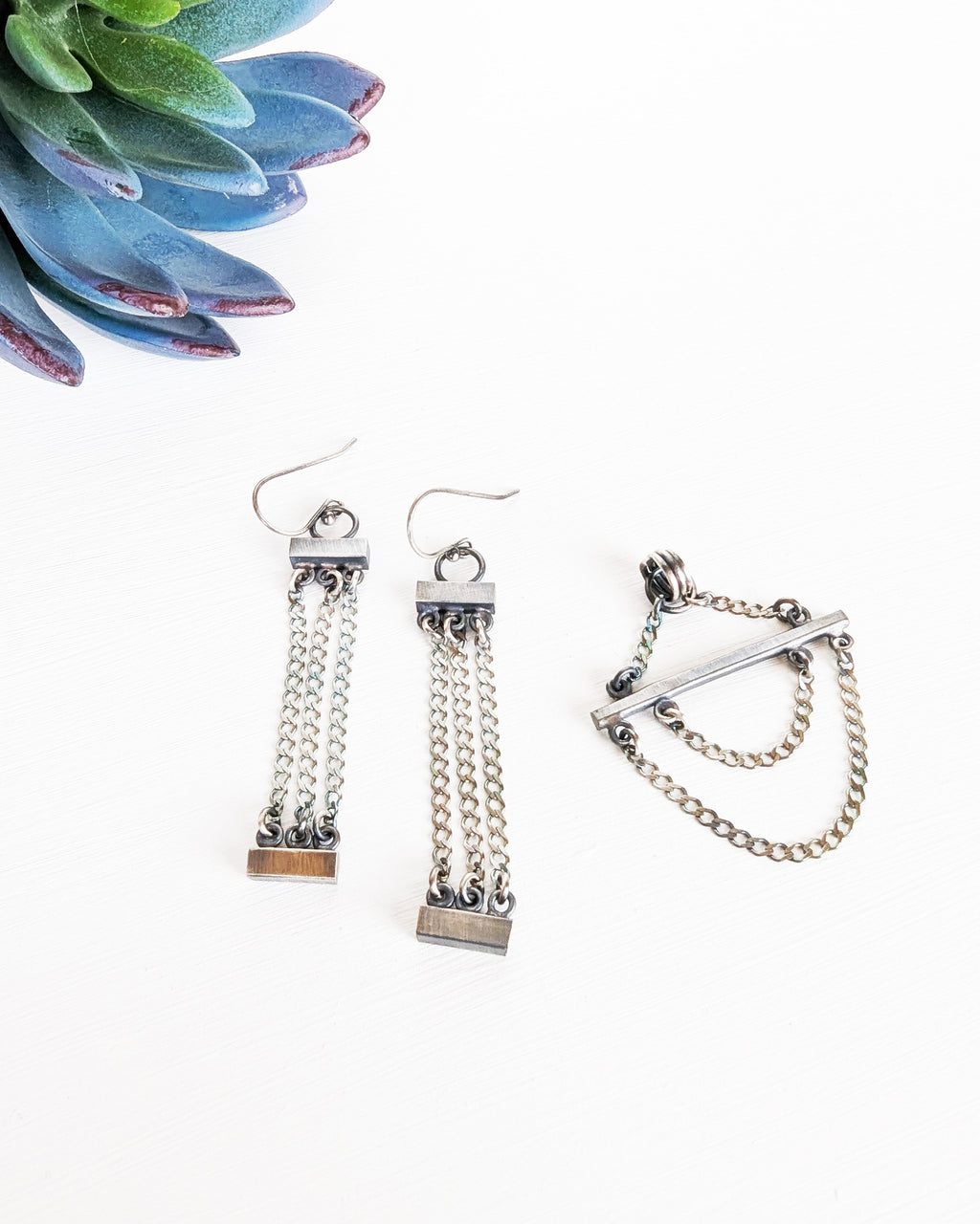 minimalist artisan sterling silver necklace with architectural design paired with complimentary earrings, not included